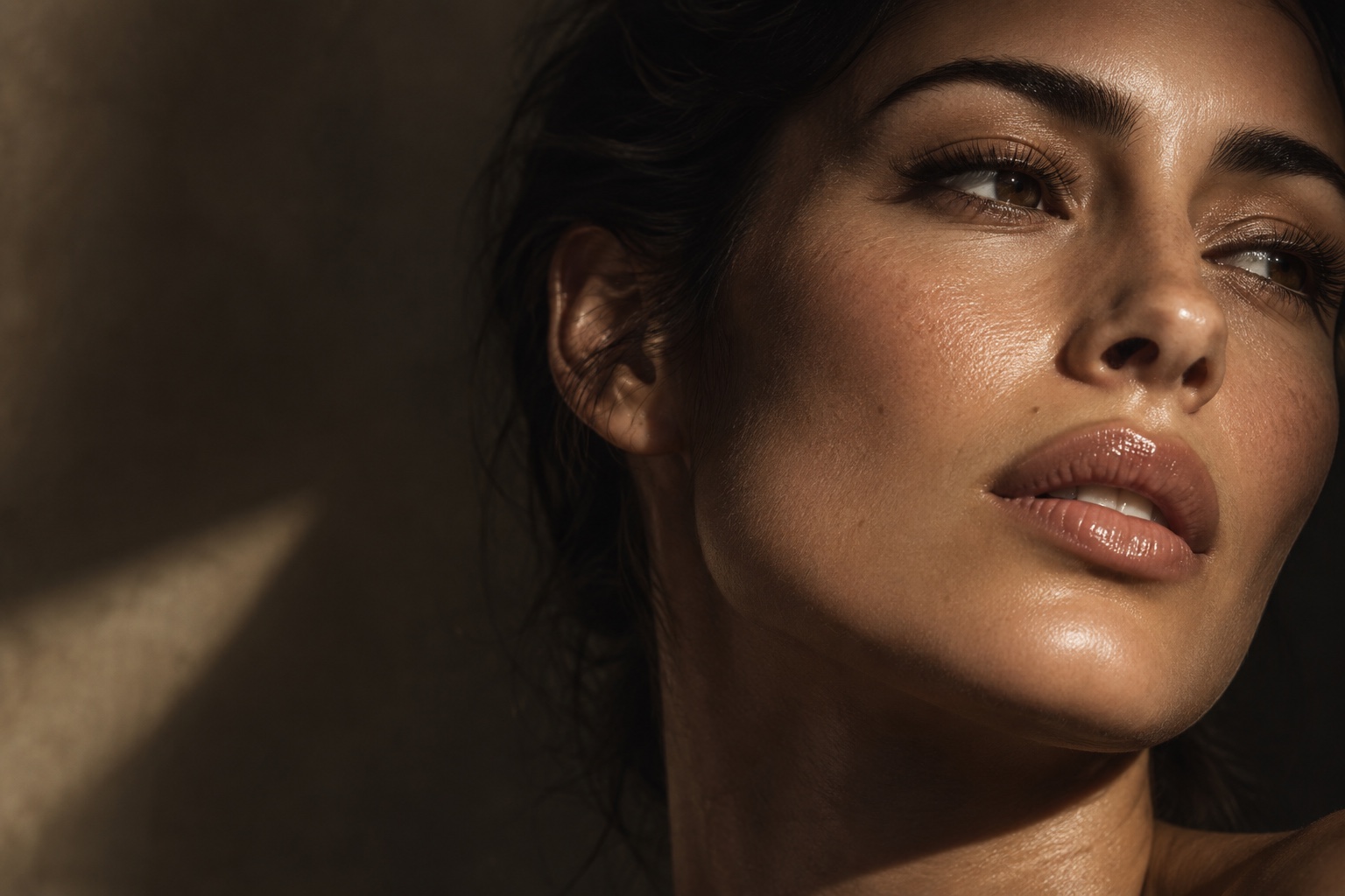 Warm, cinematic beauty campaign portrait with luminous skin and lifted lashes